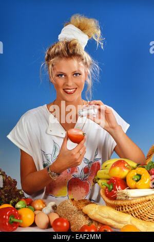Femme blonde avec du sel tomate manger pour le petit déjeuner Banque D'Images