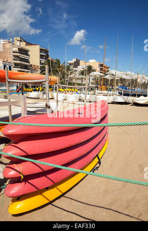 Les kayaks en plastique empilés pondent sur la plage de sable en Espagne Banque D'Images