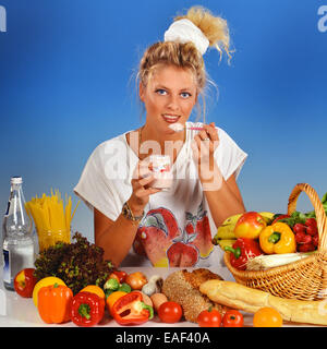Femme blonde manger du yogourt Banque D'Images