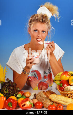 Femme blonde manger un yaourt Banque D'Images