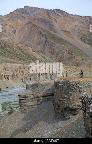 Cycliste au-dessus d'une rivière, au pied de la Gata Loops, sur la route de Manali à Leh à travers l'himalaya Banque D'Images