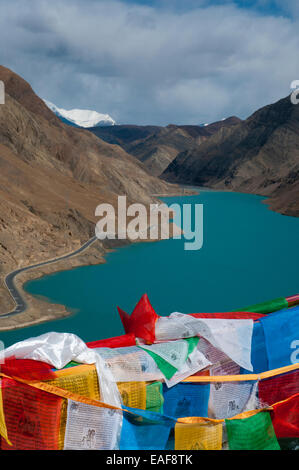 Un bras du lac Yamdrok-Tso dans l'ouest du Tibet, avec les drapeaux de prières Banque D'Images