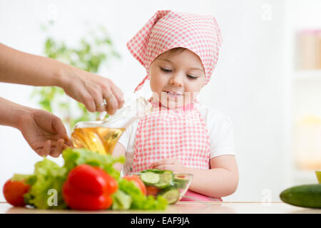 Petite fille avec des légumes sur la cuisine Banque D'Images