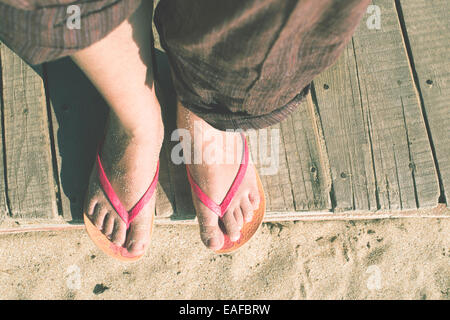 Les pieds en tongs sur la plage Banque D'Images