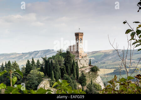 La tour de l'horloge médiévale entourée de cyprès et autres arbres, vue du rocher de Brisighella en Emilie Romagne, Italie. Banque D'Images