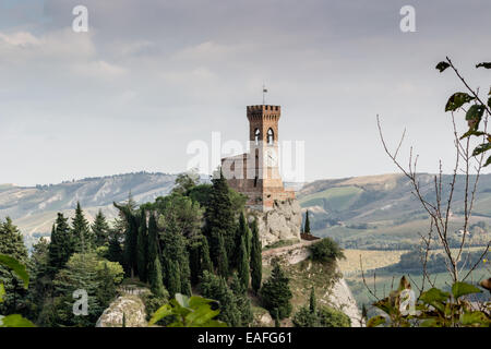 La tour de l'horloge médiévale entourée de cyprès et autres arbres, vue du rocher de Brisighella en Emilie Romagne, Italie. Banque D'Images