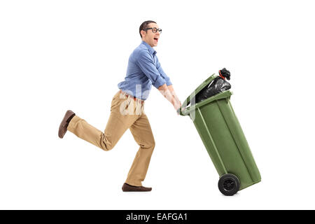 Un homme excité poussant une poubelle isolé sur fond blanc Banque D'Images