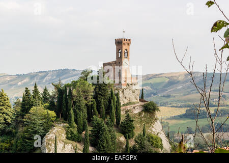 La tour de l'horloge médiévale entourée de cyprès et autres arbres, vue du rocher de Brisighella en Emilie Romagne, Italie. Banque D'Images