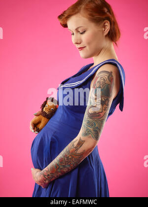 Happy pregnant woman garde les mains sur son ventre Banque D'Images