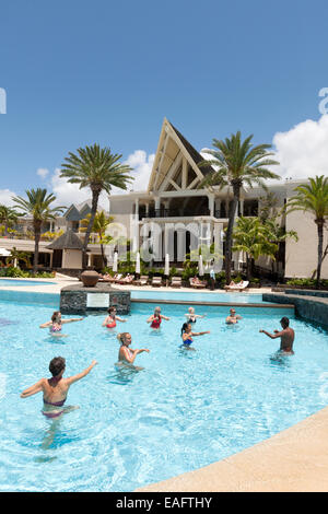 Les clients de l'hôtel faire une classe d'aérobic de l'eau dans la piscine de la résidence, un hôtel de luxe 5 étoiles, Belle Mare, Ile Maurice Banque D'Images