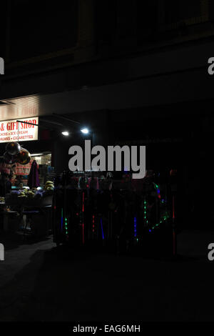 Portrait de nuit des bâtons colorés sur la chaussée en face de boutique vendant des cadeaux, rock, Blackpool Illuminations Banque D'Images