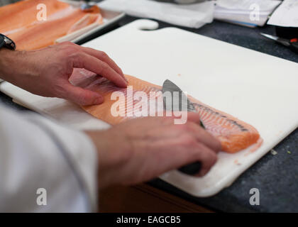 Le détartrage, Chef d'un filet de saumon cru avec un couteau chef Banque D'Images