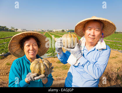 Happy senior couple standing in front of farmland Banque D'Images