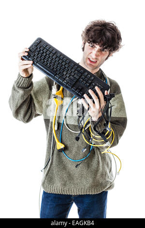 Un mec avec des câbles emmêlés et un clavier struggeling pour obtenir de l'aide de l'ordinateur. isolated on white Banque D'Images