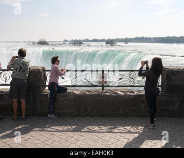 Deux jeunes femmes d'apparence asiatique taking photograph at Horseshoe Falls, Niagara Falls, Ontario, Canada. Banque D'Images