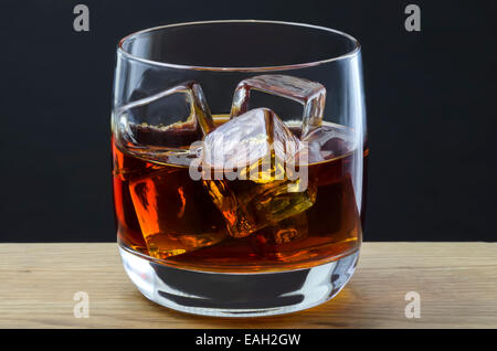 Un grand whisky versé sur des glaçons dans un verre ordinaire Banque D'Images