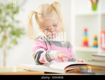 Dans eyeglases drôle kid livre de lecture à la maison Banque D'Images