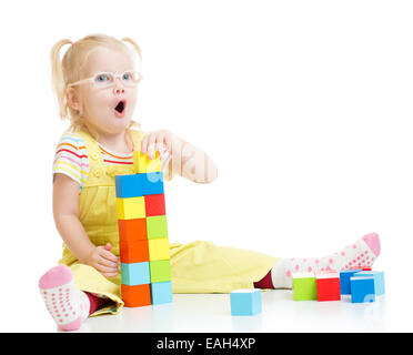 Dans eyeglases drôle kid faire tower en utilisant les blocs avec des lettres Banque D'Images