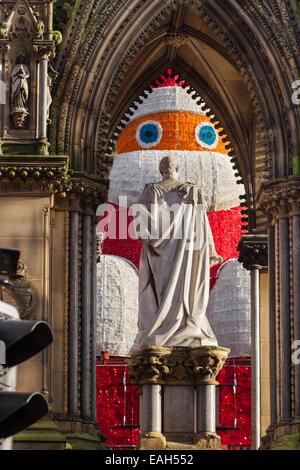 Manchester, UK 14 Novembre, 2014. Négligé...Here's looking at you ..accepter que certains jours vous êtes le pigeon, et certains jours vous êtes la statue' ..Noël Stare' ou 'voir' à travers l'arche comme Prince Albert, encadrée de façon spectaculaire sur les arches cranté Albert Memorial fait face à un très gros père noël géant surdimensionné iconique qui a été érigé à l'hôtel de ville les bâtiments. L'allumé en Père Noël, qui a remplacé le Père Noël gonflable qui permet de s'asseoir à sa place au-dessus de l'entrée de la mairie, est devenue aussi célèbre que les marchés eux-mêmes. Banque D'Images