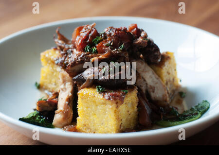 La polenta au poulet braisé aux légumes verts sautés de saison délicieux Banque D'Images