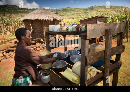 Une femme plats sèche sur un plat etendoir devant son domicile à Ndishania Bukwo, village, district de l'Ouganda. Banque D'Images