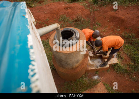 Les élèves se lavent les mains à l'extérieur du bloc toilettes des garçons à l'école primaire en Kaptomologon Bukwo, de l'Ouganda en utilisant l'eau d'une pluie Banque D'Images