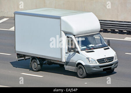 Vue du dessus et de l'avant côté conducteur vers le bas dans Mercedes Benz blanc propre non marqué livraison van rationaliser la conduite avant courbée le long de l'autoroute du Royaume-Uni Banque D'Images