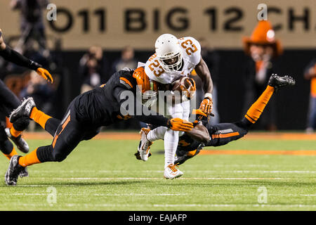 15 novembre 2104 : Texas longhorns wide receiver Daje Johnson (23) est abordé par l'Oklahoma State Cowboys coffre Tre fleurs (31) et l'Oklahoma State Cowboys attaquer défensif James Castleman (91) au cours de la NCAA football le jeu entre l'Oklahoma State Cowboys et le Texas longhorns à Boone Pickens Stadium à Stillwater, OK. Banque D'Images