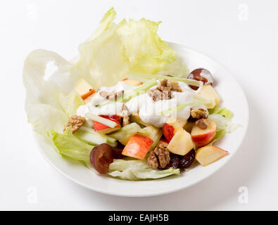 Un traditionnel salade Waldorf avec laitue, noix,raisins,apple,et des bâtonnets de céleri, surmontée d'un pansement moderne de yaourt avec Banque D'Images