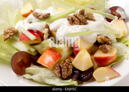 Un traditionnel salade Waldorf avec laitue, noix,raisins,apple,et des bâtonnets de céleri, surmontée d'un pansement moderne de yaourt avec Banque D'Images