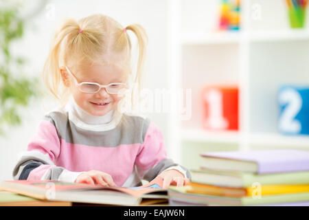 Dans eyeglases drôle enfant livre de lecture à la maison Banque D'Images