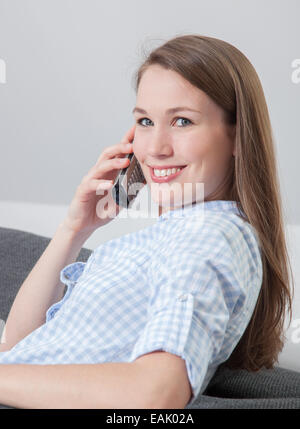 Jolie jeune femme faisant appel à la maison Banque D'Images