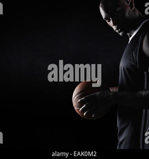 Studio shot of strong young man holding basket-ball looking at camera with copy space. Joueur de basket. Banque D'Images