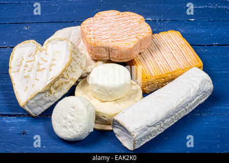 Différents fromages français sur une table en bois bleu avec les feuilles d'automne Banque D'Images