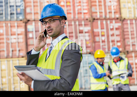 Businessman talking on cell phone près de conteneurs de fret Banque D'Images