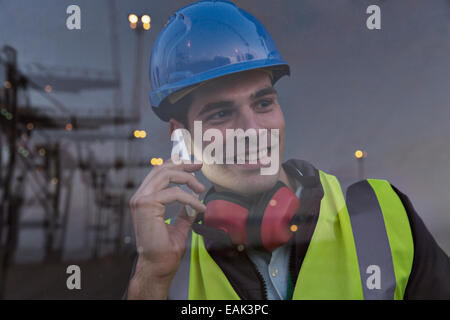 Worker talking on cell phone near window Banque D'Images