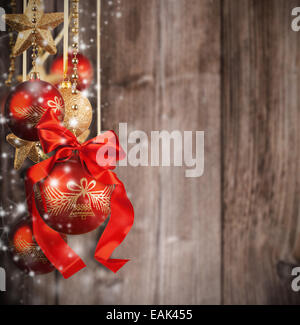 Thème de Noël avec des boules de verre rouge flou sur la texture en bois Banque D'Images