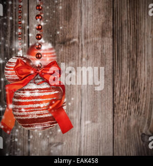Thème de Noël avec des boules de verre rouge flou sur la texture en bois Banque D'Images