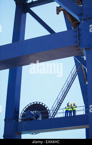 Workers standing sur crane Banque D'Images