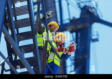 Low angle view of workers standing sur grue de chargement Banque D'Images