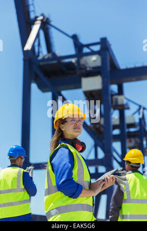 Low angle view of worker standing près de la grue de chargement Banque D'Images