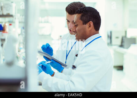 Les scientifiques using digital tablet in laboratory Banque D'Images