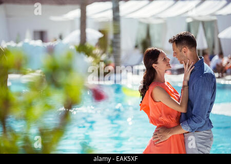 Couple debout face à face en piscine Banque D'Images