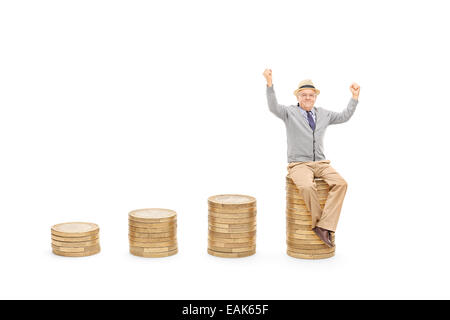 Happy assis sur une pile de pièces isolées sur fond blanc Banque D'Images