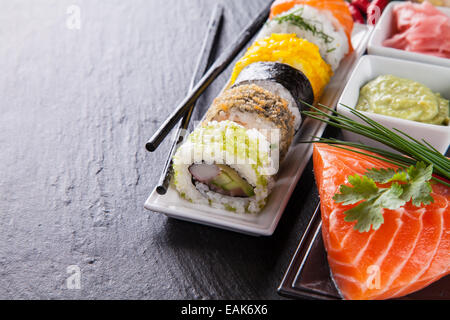 Divers types d'aliments sushi servi sur pierre noire Banque D'Images