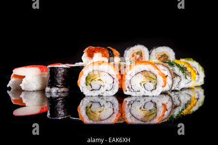 Divers genre de sushi aliments servis sur fond noir Banque D'Images