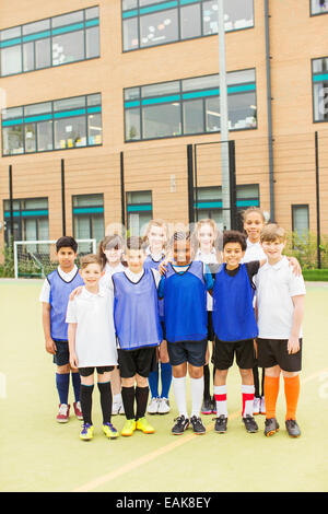 Portrait de groupe d'enfants portant des uniformes de sport en face de l'école Banque D'Images