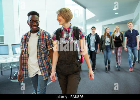 Groupe d'étudiants en marche et corridor smiling Banque D'Images