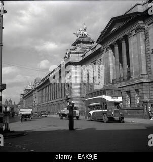 Années 1950, historique, une vue sur le grand victorian bâtiments dans columed Kingston Upon Hull city centre en tant qu'un policier ordonne à la circulation automobile. Nous voyons des voitures de l'époque, un panier, un van et un lait 45 Transport Société motorbus doubledecker aller à Preston Rd par Drypool Bridge et nouveau pont Road. Banque D'Images