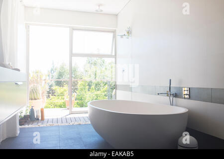 Grande salle de bains moderne avec baignoire et porte patio blanc Banque D'Images